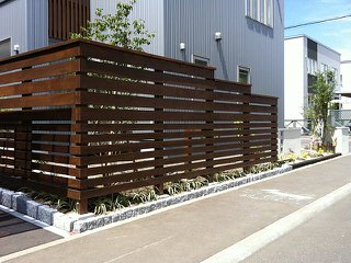 ウッドフェンス、植栽、塗り壁で歩道境界線をデザイン