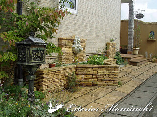 高級感のある石積みの花壇と壁泉のあるお庭